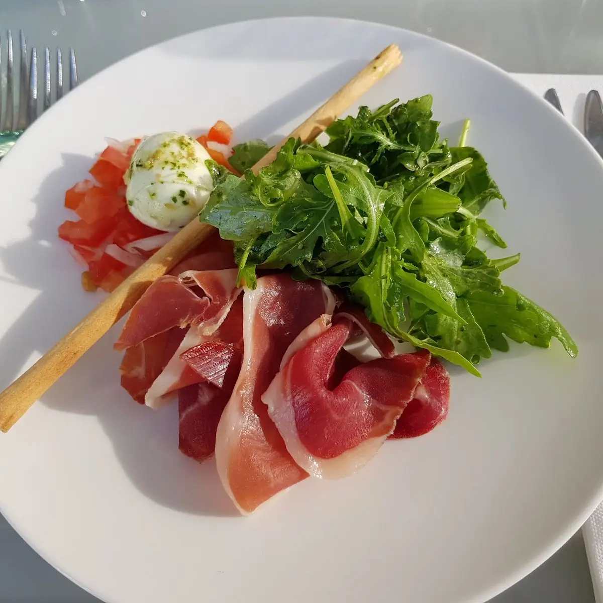 Burrata Mit Paradaisertatar Parmaschinken Marinierter Rucola Und Pinienkernen