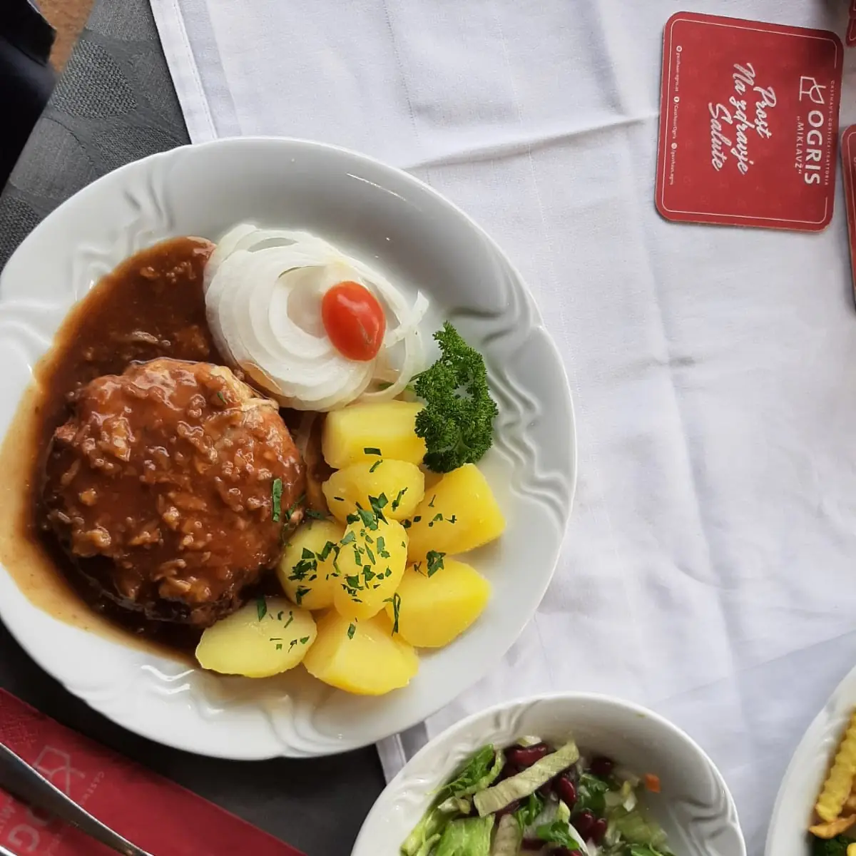 Pleskavica In Pikanter Zwiebelsauce Mit Kräuterkartoffeln