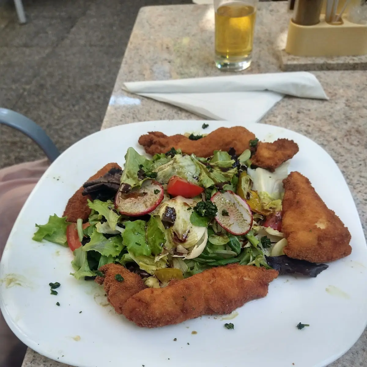 Panierte Hühnerbruststreifen Auf Blattsalat Mit Kernöl