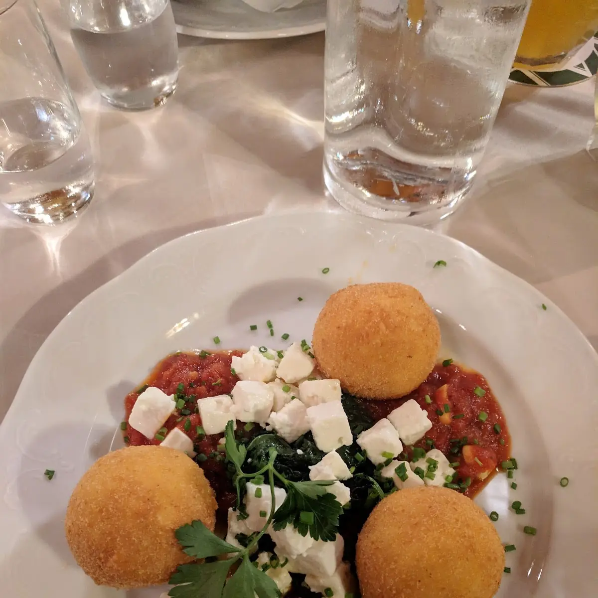 Gebackene Polenta-schafkäseknöderl Auf Blattspinat & Geschmolzenem Paradeiser