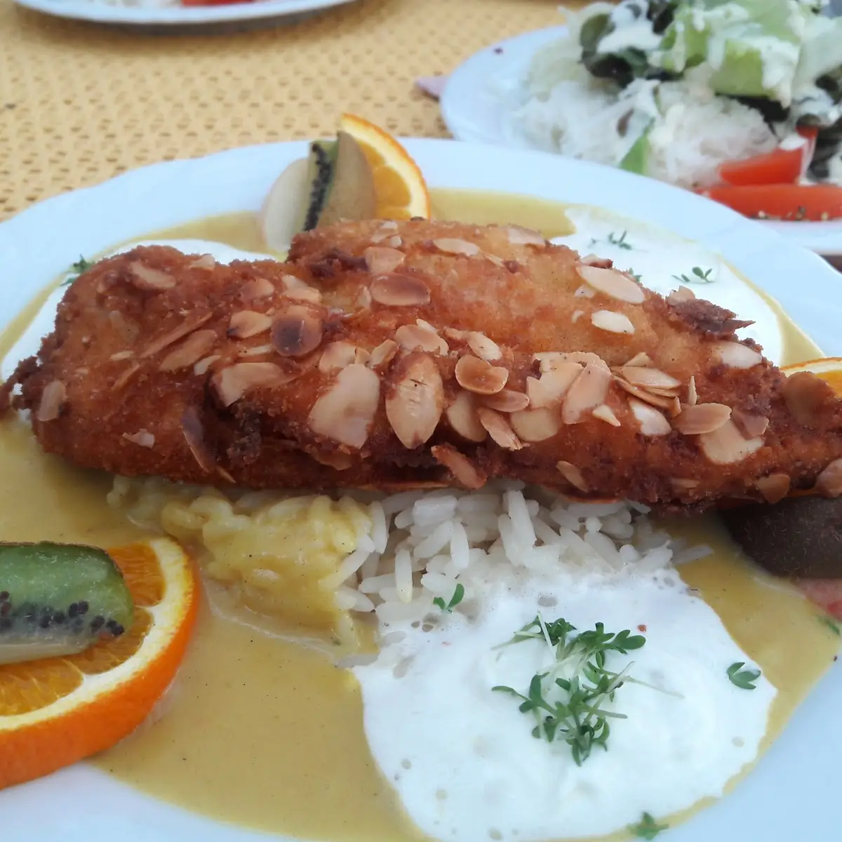 Hühnerfilet In Mandelkruste Auf Reissockel Mit Currysauce Und Früchten