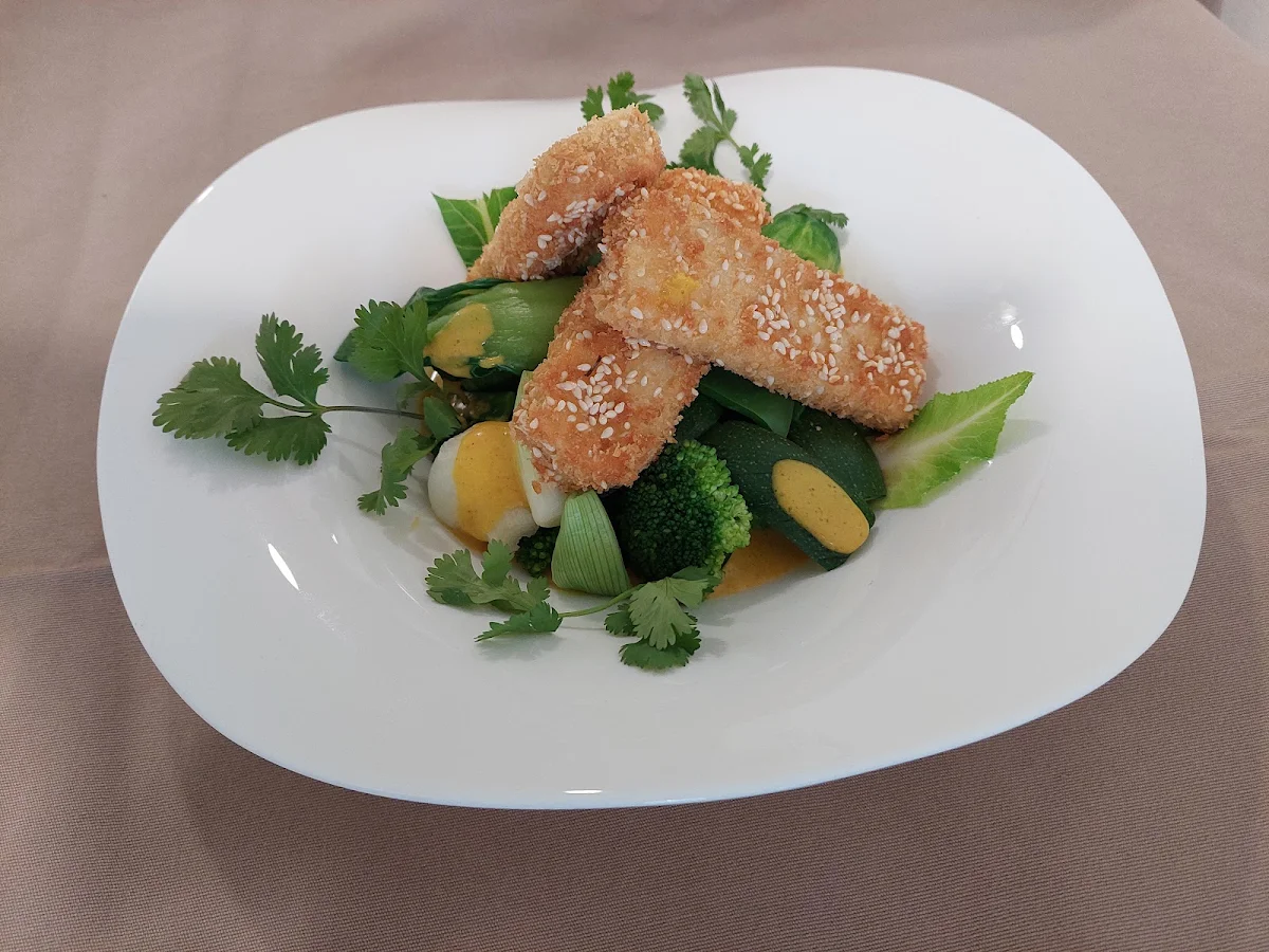 Tofu In Sesam-pankokruste Auf Grünen Gemüse Mit Currysauce
