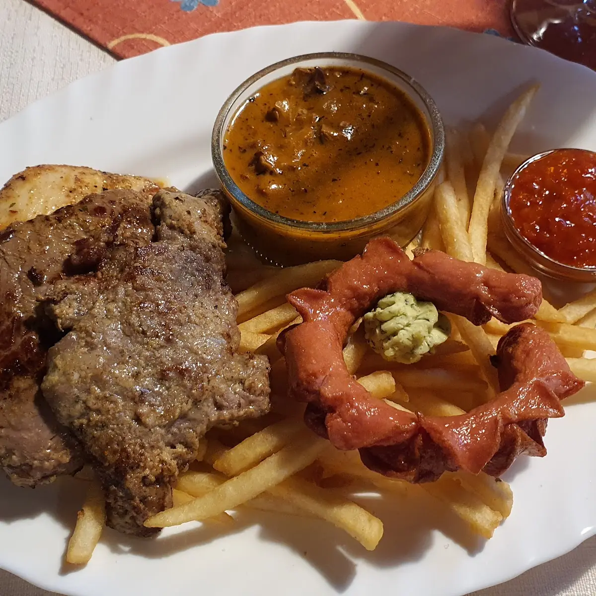Grillplatte Mit Schweine- Rinder- Und Hähnchenfilet Sowie Einem Grillwürstchen