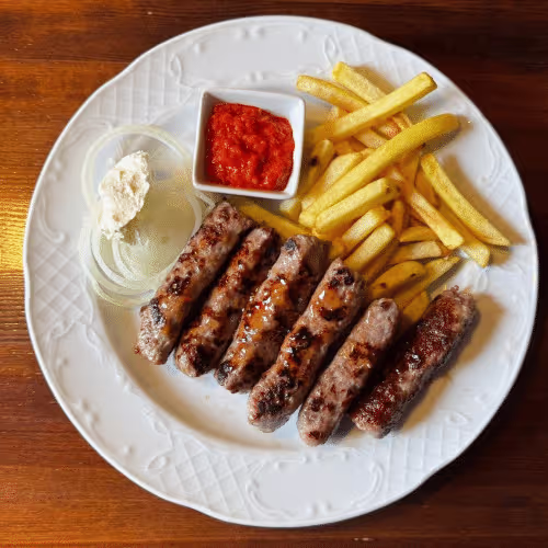 Cevapcici (vom Grill) mit Pommes Frites, Ajvar und Zwiebelscheiben