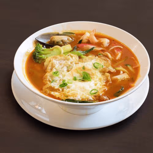 Hausgemachte Nudelsuppe mit Thai-Rot-Currysauce und Meeresfrüchten (scharf)