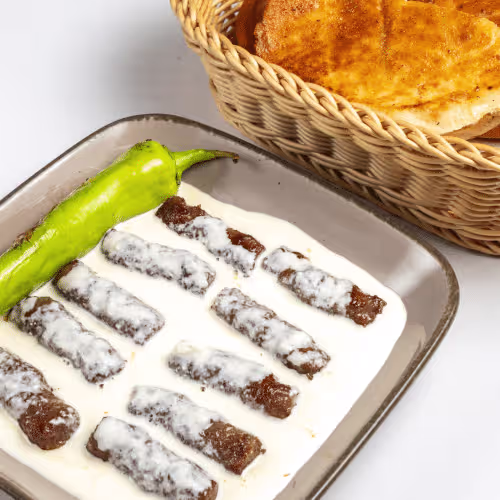 Cevapcici (10 Stück) in Kajmak