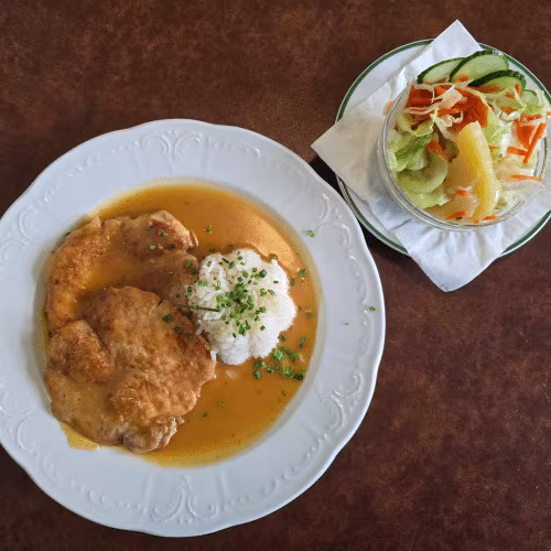 Naturschnitzel im Saft mit Reis und Salat.