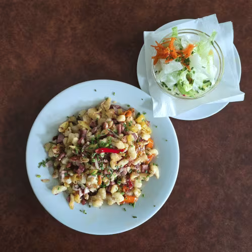 Bauernspätzle mit Speck, Zwiebeln, Pfefferoni und Beilagensalat.