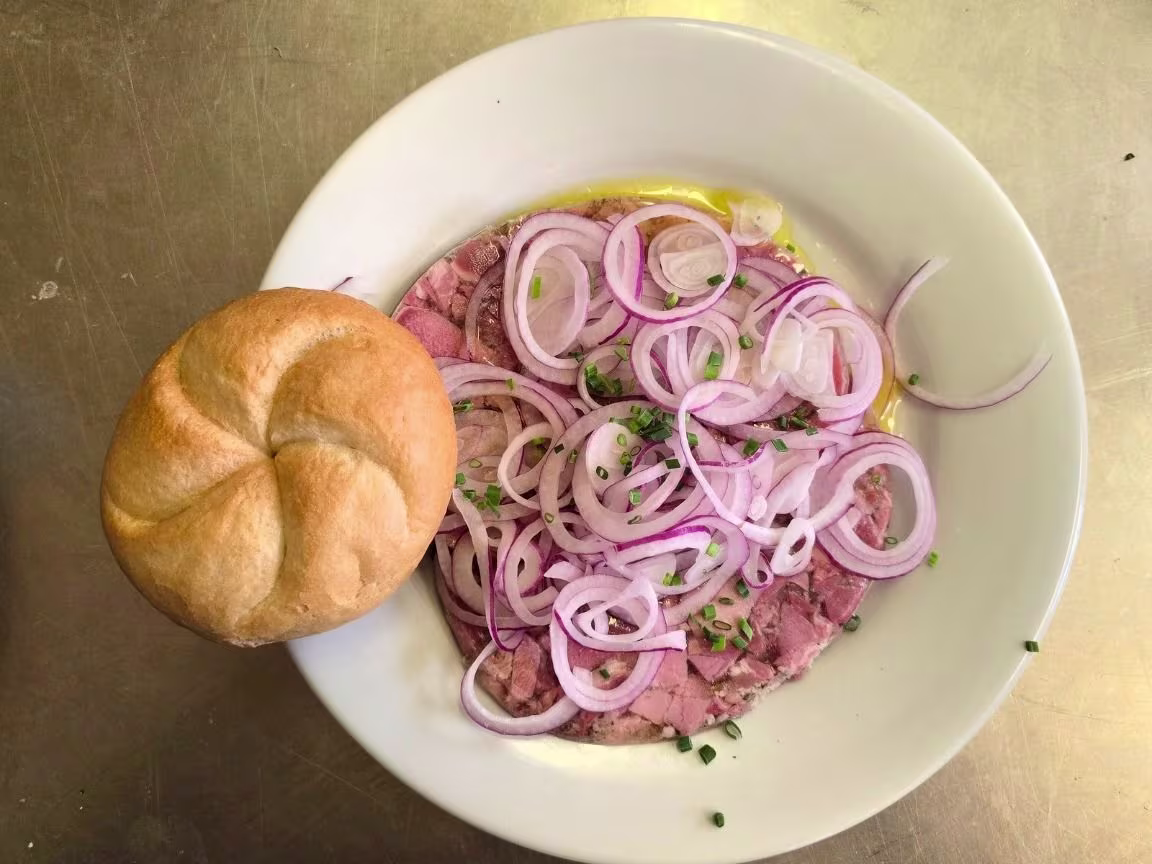 Presswurst in Essig und Öl mit Gebäck.