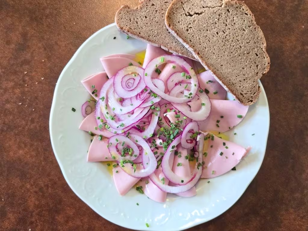 Extrawurst in Essig und Öl mit Gebäck.