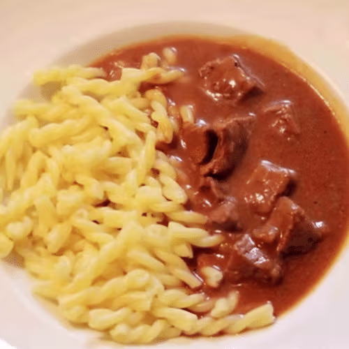 Schweinegulasch mit Nudeln und gemischtem Salat