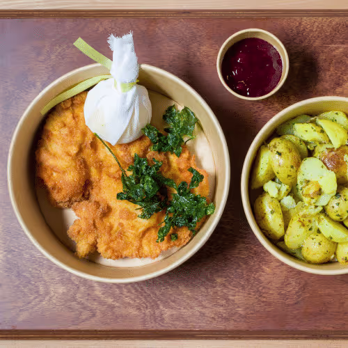 Schnitzel vom Woazschwein mit Petersilienerdäpfel u.Preiselbeer