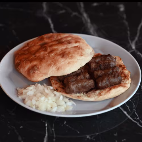 Cevapcici auf Fladenbrot mit Zwiebeln (7 Stück)