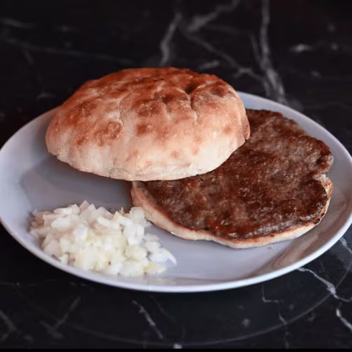 Pljeskavica auf Fladenbrot mit Zwiebeln